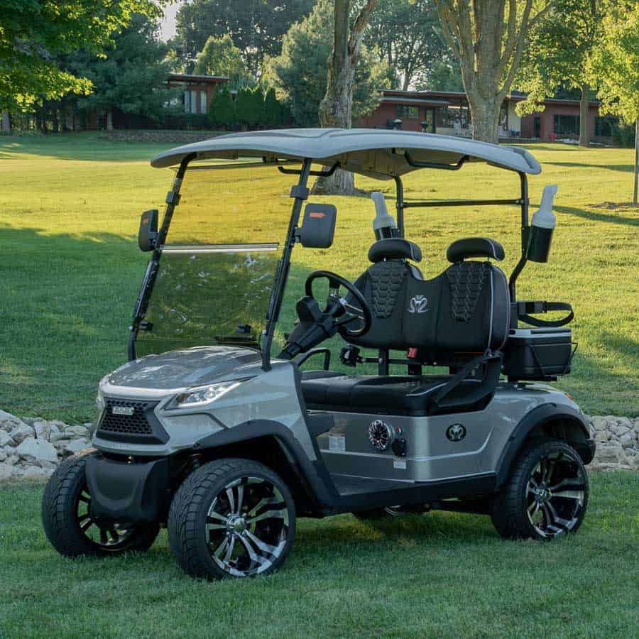 Gray Venom Electric Vehicles lifted golf cart with black diamond-stitched seats and custom alloy wheels parked on a golf course lawn, showcasing a modern street-legal Venom EV cart.