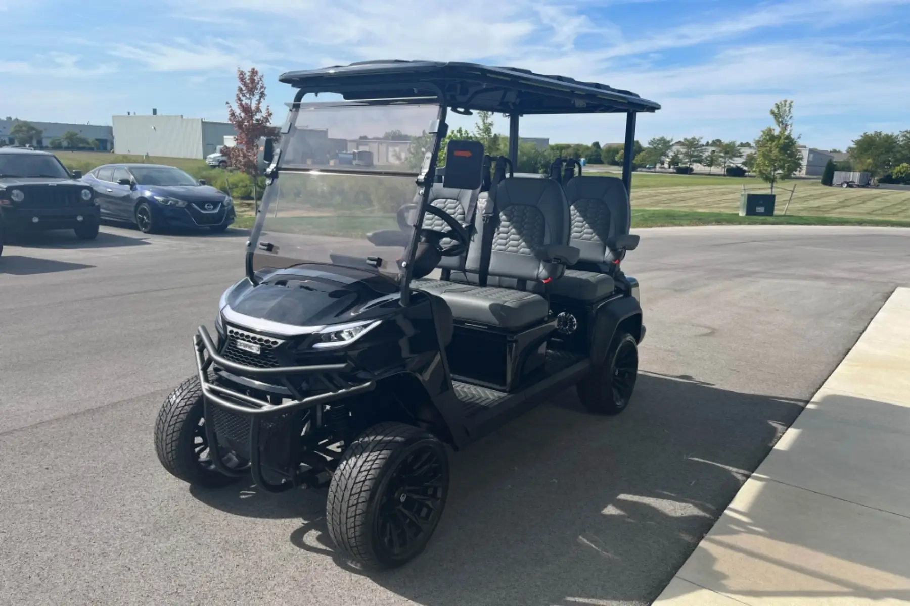 Black lifted 4-passenger golf cart for sale at a golf cart dealership in Indianapolis, IN, featuring premium seats, off-road tires, and street-ready design.