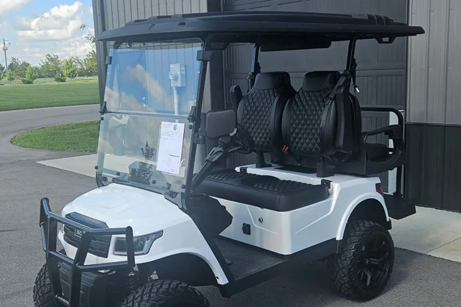 White lifted electric golf cart with black seats for sale at an Indianapolis dealership