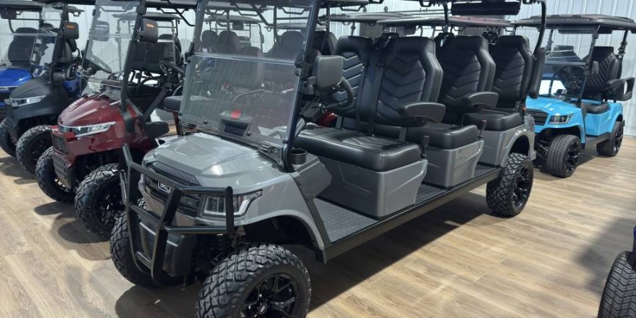 Gray extended LUX electric golf cart with six black captain’s seats and off-road wheels on display at Hurricane Golf Carts in Winchester, KY