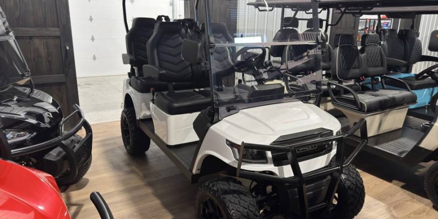 White Breezy lifted golf cart with black premium seats and off-road tires at Hurricane Golf Carts showroom in Winchester, KY.