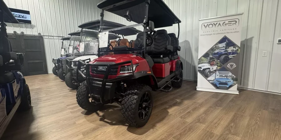 Red Voyager golf cart on display inside the Hurricane Golf Carts showroom.